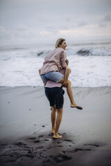 young beautiful couple in love walking at sunset by the ocean, couple relaxing in Bali, vacation in Bali, travel together, hug, love