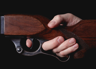 Lever-action hunting rifle detail with finger squeezing trigger