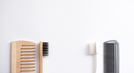 bamboo toothbrush and wooden  hairbrush and plastic toothbrush and comb   on white background with free copy space, flat lay, plastic and no plastic, concept - eco friendly choice