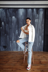 Full-length portrait with black hair on a gray background in the studio.