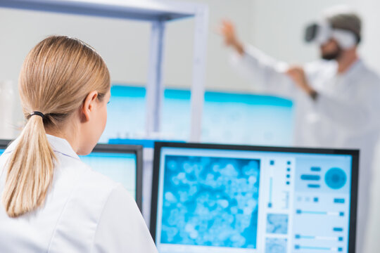 Genetic engineers are using Virtual Reality technology. Professional team of scientists is working on a vaccine in a modern scientific research laboratory. Science of future.