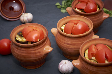 Fototapeta premium chanakhi in pots cooked for baking in the oven close-up next to cilantro
