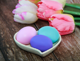 Fototapeta na wymiar colorful Easter eggs and pink tulips