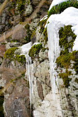 Fototapeta na wymiar Ice waterfall, frozen water on a rock, snowy rock 
