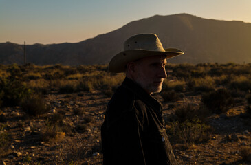 Adult man in cowboy hat on Tabernas desert during sunset. Almeria, Spain