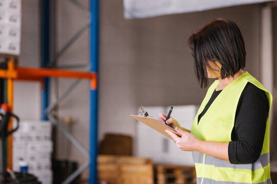 Anonymous woman taking notes while checking supplies