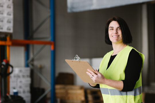 Happy woman taking notes while checking supplies