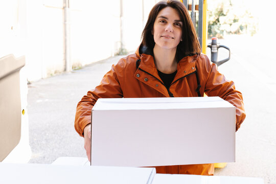 Woman loading box into truck