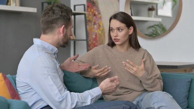Serious Man Talking to Woman While Sitting on Sofa 