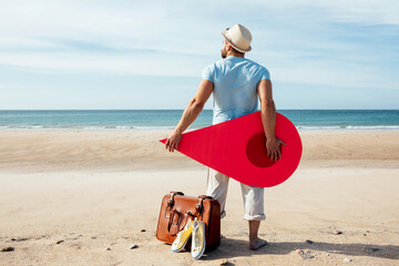 Traveling man with red map pointer on seashore