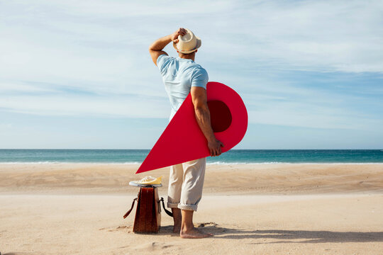 Traveling man with red map pointer on seashore