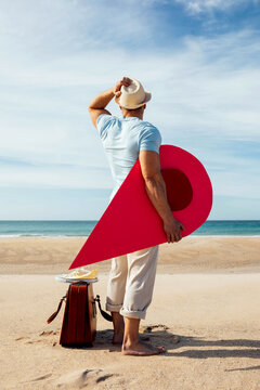 Traveling man with red map pointer on seashore