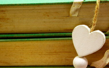 Wooden heart on green books. Love valentine concept