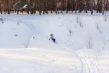 woman skiing down a hill in the snow and falls