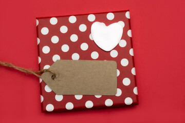Empty Blank texture canvas paper card, gift box with polka dots and white heart on a red background. Love valentine concept. Flat lay