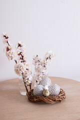 Glamorous Easter eggs in a nest with flowers. Minimalist table decorations at home for the spring holiday