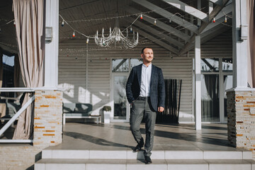 A man, a businessman in a blue jacket, descends the steps of a wooden house. Photography, business.