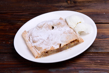Piece of apple pie served with ice cream, fruit baking