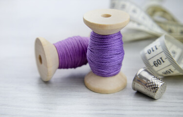 A spool of purple thread on a wooden table. Sewing accessories. Hobbies and recreation,sewing...