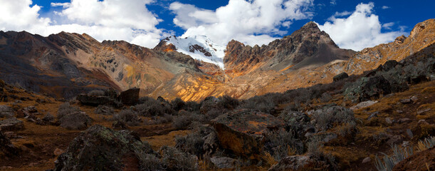 Panorama of snowy mountains and valley in the remote Cordillera Huayhuash Circuit near Caraz in Peru.