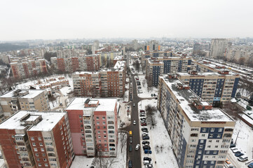Fototapeta premium view from the window of a new building on the snow-covered roofs of houses in the old part of the foggy city