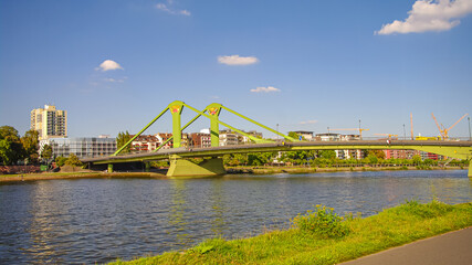 Cityscape at the bank of Main river with modern skyscrapers and old buildings in financial and historic downtown of Frankfurt, at sunset and sunny day.