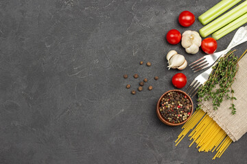 Spaghetti and vegetables, two forks and thyme on napkin.