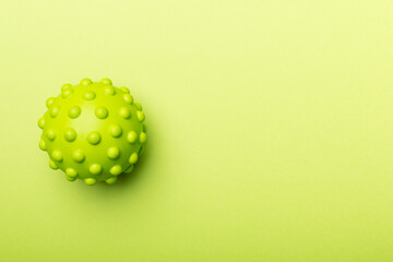 Green spiky ball toy for pet on color background