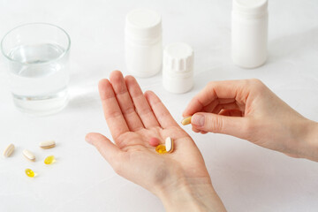 Woman's hands holding medical capsules, women taking supplements or vitamin type capsules.