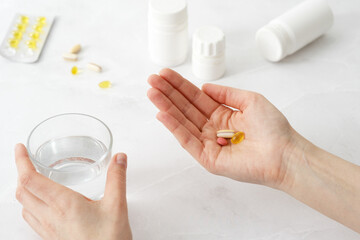 Woman's hands holding medical capsules, women taking supplements or vitamin type capsules.