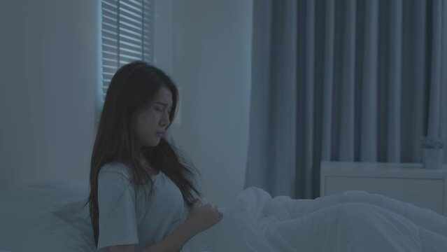 Asian beautiful sick girl suffering from hurt stomachache in bedroom.