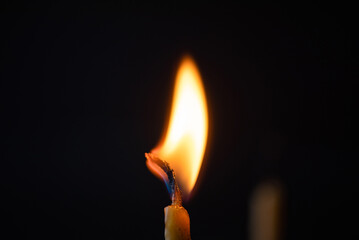 Burning candle, smoke on a dark background.