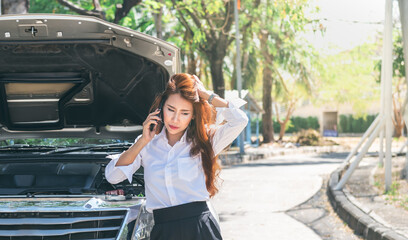 Asian business woman using a mobile phone To ask for help, because her pickup truck was broken, During travel, to people and transportation concept. © Anatta_Tan