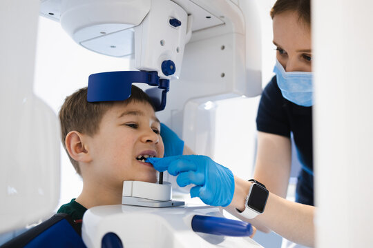 Radiographer taking panoramic teeth radiography to a little boy using modern x-ray machine