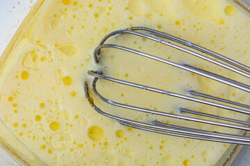 dough in bowl and whisk on white background top view
