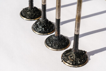 Engine valves in oil covered with soot. Heat-resistant steel. Automotive, repair servicing.