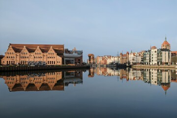 Panorama of Old Town in Gdansk and Motlawa river with ships, Poland. Amazing reflections in water. Letters of name of Poland on bank.
