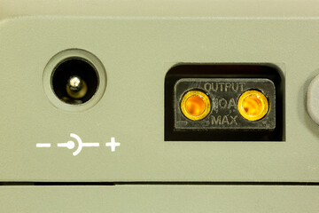 External power output sockets on the camera battery. Negative positive symbols and maximum output power in amps.
