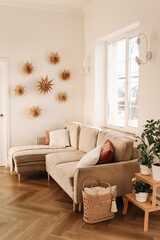 Bright minimalistic interior of a cozy living room with sofa cushions and a window in a Scandinavian interior in a comfortable apartment. Selective focus