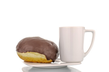 One flavorful chocolate donut with a white cup on a white saucer, macro, isolated on a white background.