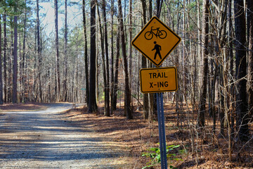 Trail crossing X-ing sign on woodland path
