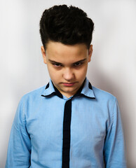 The boy in the blue shirt is 12 years old.Atelier.White background.Looks at the camera angry