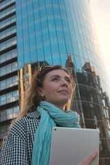 Fototapeta na wymiar Successful woman with tablet near futuristic glass business center