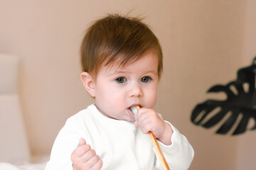 Cute Kid saw the toothbrush for the first time, looks at it with interest. The first teeth cleaning for a small child girl