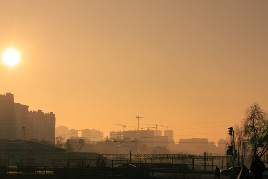 Dawn over the foggy city. Rising sun over a large construction site on the horizon © Klochkov