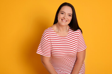 Obraz premium Beautiful overweight woman with charming smile on yellow background. Space for text