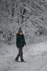 a boy walks in a snow park