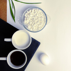Natural products for breakfast: cottage cheese, egg, kefir, black coffee. Black and white contrast. View from above. Place for an inscription