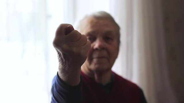 Elderly woman showing an obscene hand gesture
