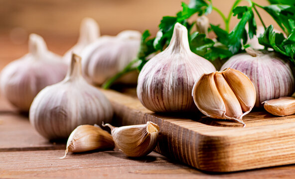 Cloves of fresh garlic on the table. On a wooden background. High quality photo